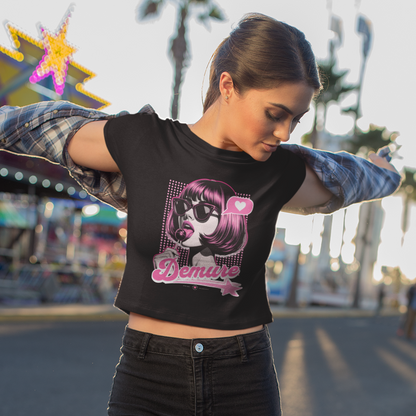 Woman wearing a black graphic crop top holding her arms out in an amusement park.