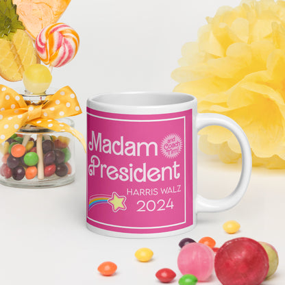 A glossy mug on a white surface surrounded by candy.